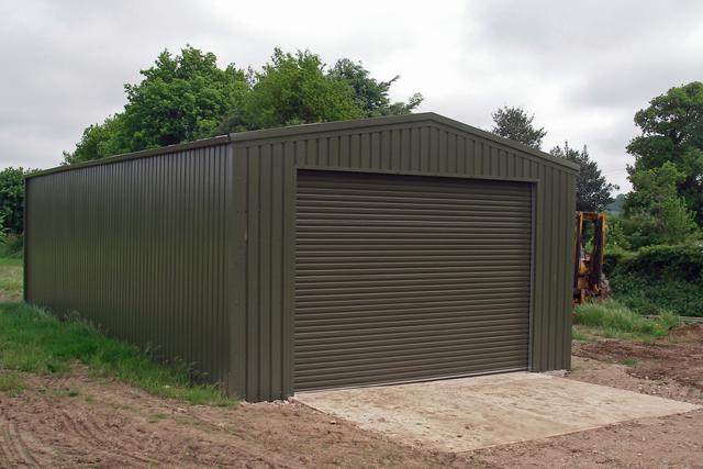 A dark green building with a single large closed roller door